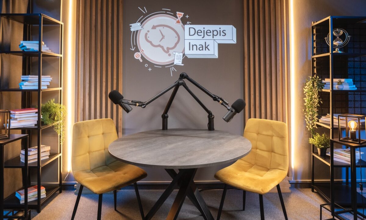 Moderné variabilné podcastové štúdio s dvoma mikrofónmi, stolom, stoličkami a svetelným logom. Podcastové štúdio Bratislava – profesionálne nahrávanie.